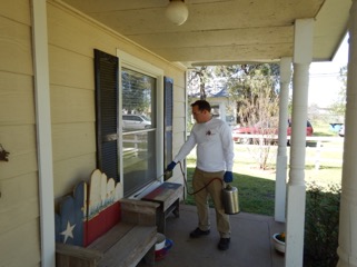 employee from Jones Ldybug spraying the front porch of a house